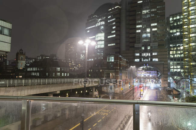 View of rain falling over city at night — Stock Photo