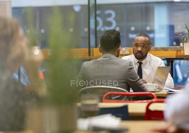 Бізнесмени говорять, працюють в кафе — стокове фото