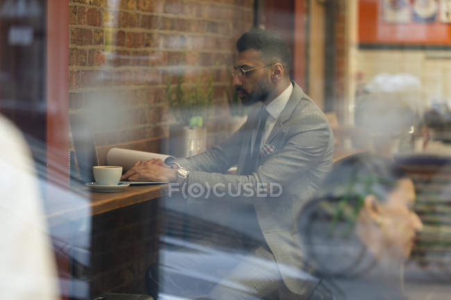 Uomo d'affari che lavora al computer portatile in caffè — Foto stock