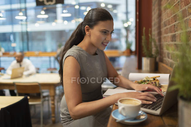 Businesswoman working at laptop in cafe — Stock Photo