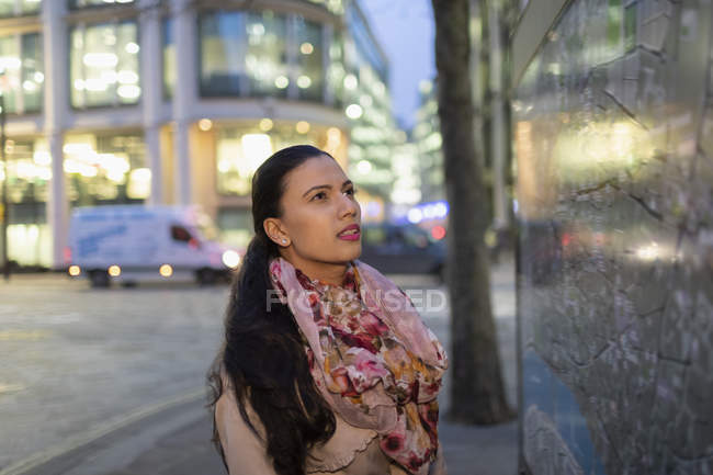 Businesswoman looking at city map on urban street at night — Stock Photo