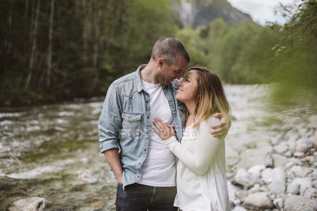 Liebevolles Paar umarmt sich am Flussufer — Stockfoto