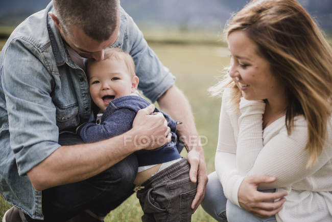 Родители обнимают счастливого маленького сына — стоковое фото
