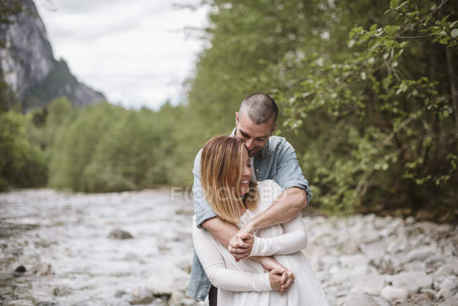 Affectionate couple hugging along stream — Stock Photo