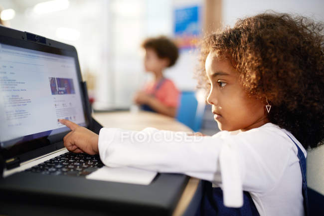 Цікава дівчина використовує ноутбук — стокове фото
