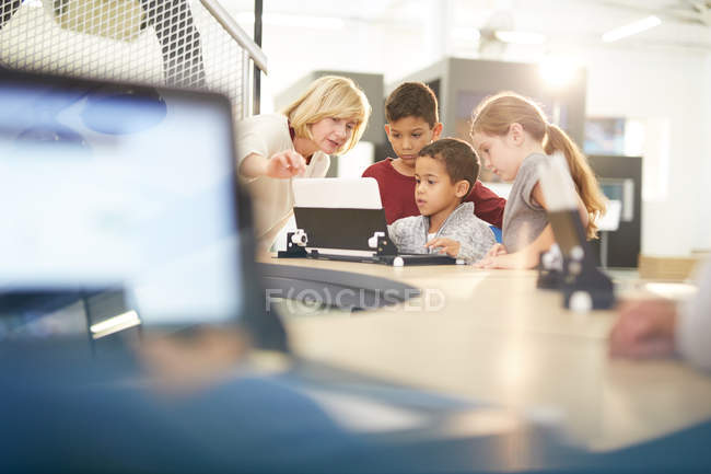 Professor e alunos usando laptop — Fotografia de Stock