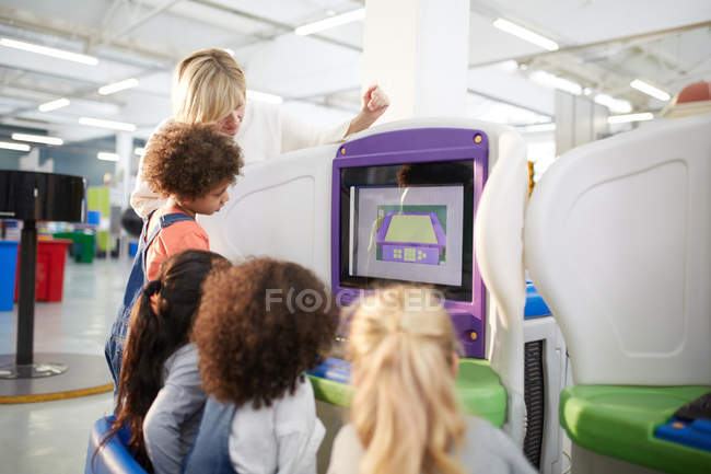 Teacher and students at interactive exhibit in science center — Stock Photo