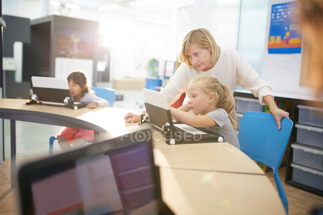 Profesor y estudiante usando laptop - foto de stock