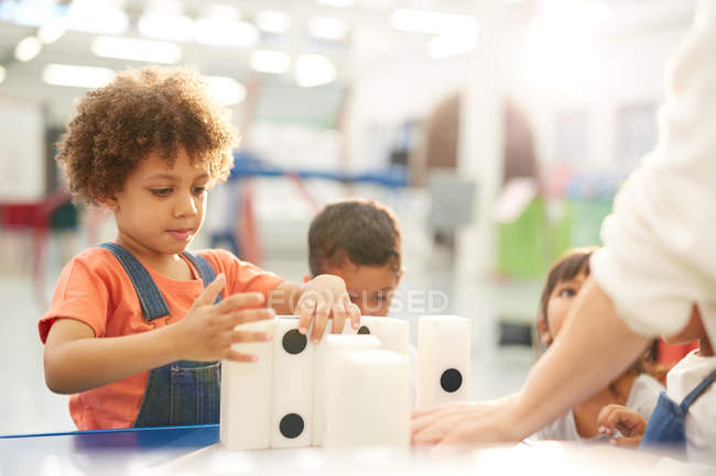 Curiosi bambini che giocano con grandi domini nel centro scientifico — Foto stock