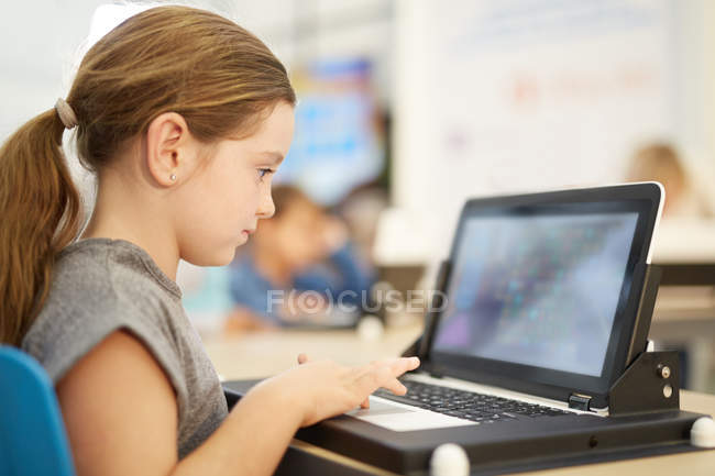 Girl playing game on laptop — Stock Photo