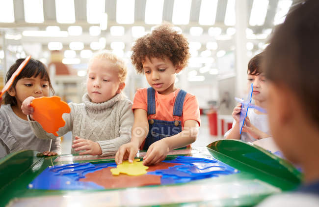 Kids playing at interactive exhibit in science center — Stock Photo