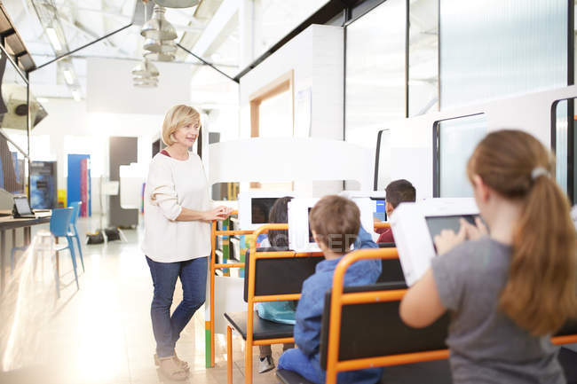 Teacher and students using touch screen computers — Stock Photo