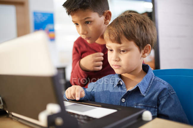 Meninos focados usando laptop — Fotografia de Stock
