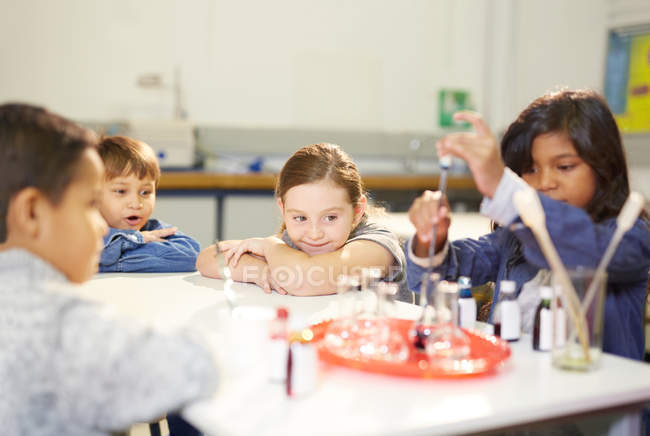 Niños curiosos realizando experimentos científicos - foto de stock