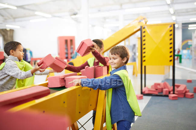 Niños jugando con ladrillos de juguete en la exposición de construcción interactiva en el centro de ciencia - foto de stock