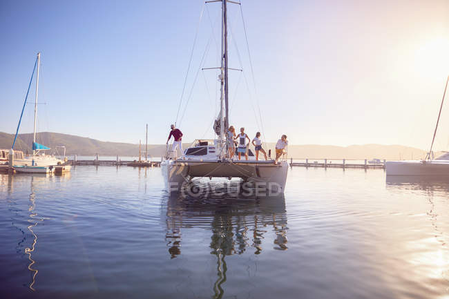 Friends on catamaran in sunny harbor — Stock Photo