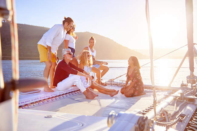 Amigos relajándose en el soleado catamarán - foto de stock