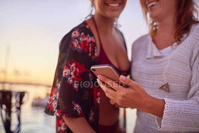 Fechar as mulheres jovens usando telefone inteligente — Fotografia de Stock