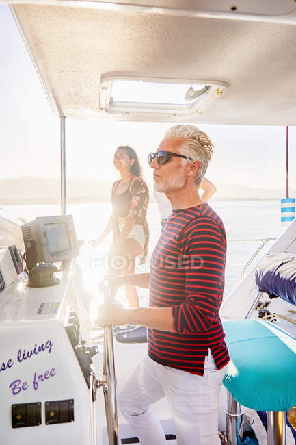Hombre al timón en barco soleado - foto de stock