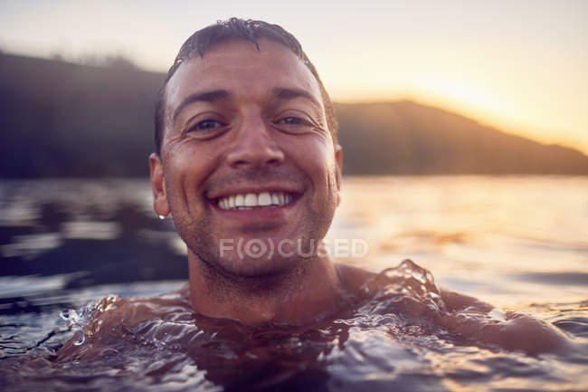 Primer plano retrato sonriente, hombre despreocupado nadando en el océano - foto de stock