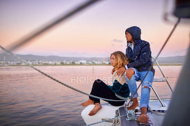 Casal jovem relaxante no barco ao pôr do sol — Fotografia de Stock