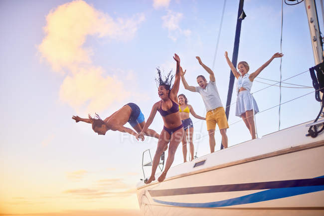 Amici giocosi che saltano dalla barca — Foto stock