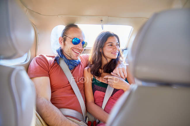 Прихильна пара їде на задньому сидінні автомобіля — стокове фото