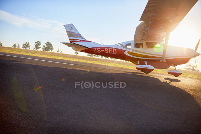 Avión de hélice aterrizando en asfalto soleado - foto de stock