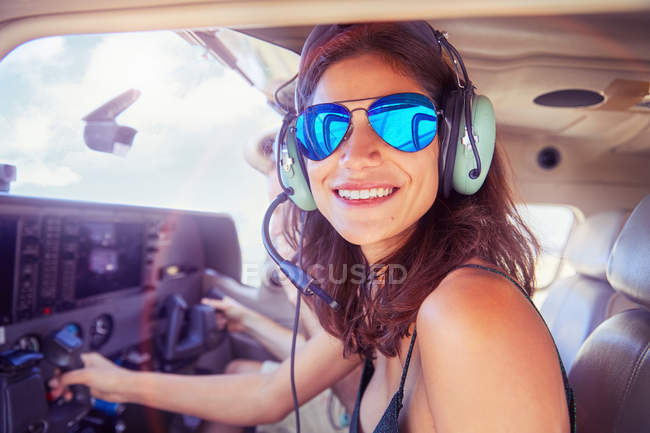 Portrait smiling, confident young woman flying airplane — Stock Photo