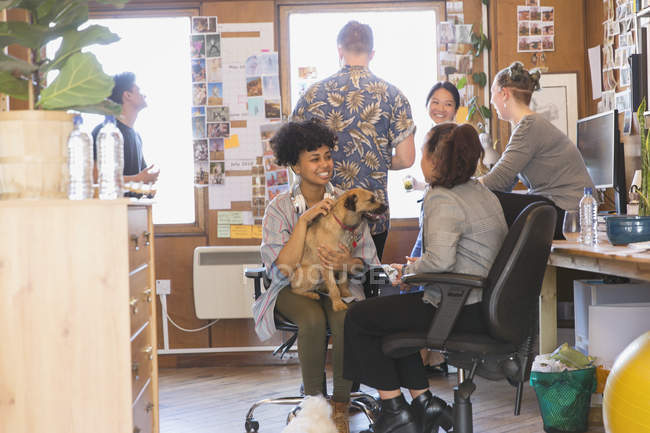 Creative business people with dog in office — Stock Photo