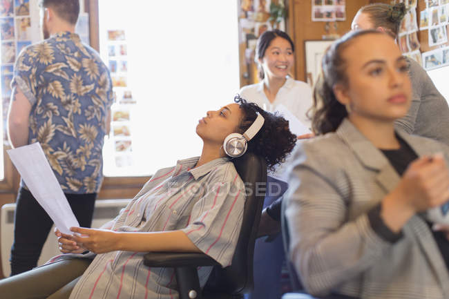 Creative businesswoman with headphones listening to music in office — Stock Photo