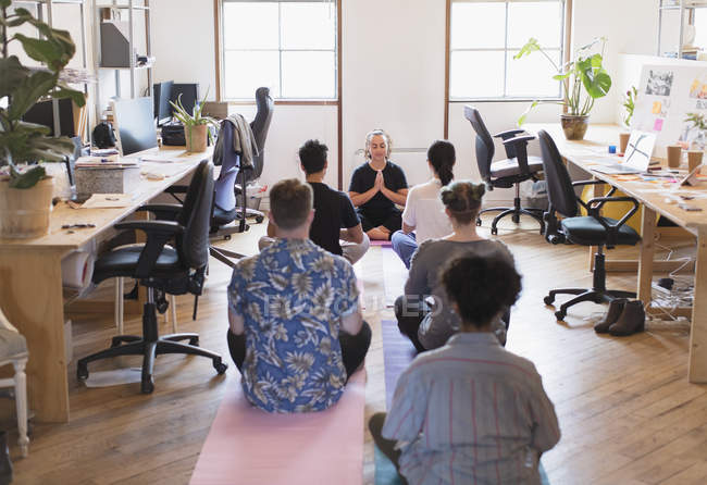 Творческие бизнесмены медитируют в офисе — стоковое фото