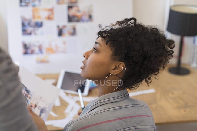 Attentive creative female designer reviewing proofs in office — Stock Photo