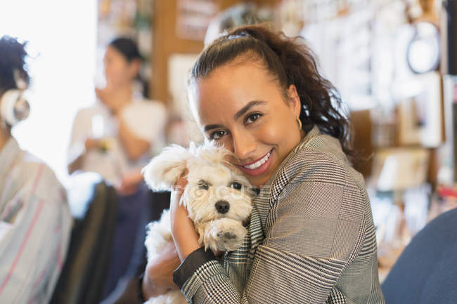 Portrait happy businesswoman with cute dog in office — Stock Photo
