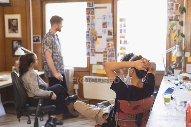 Creative designers brainstorming, reviewing photograph proofs in office — Stock Photo