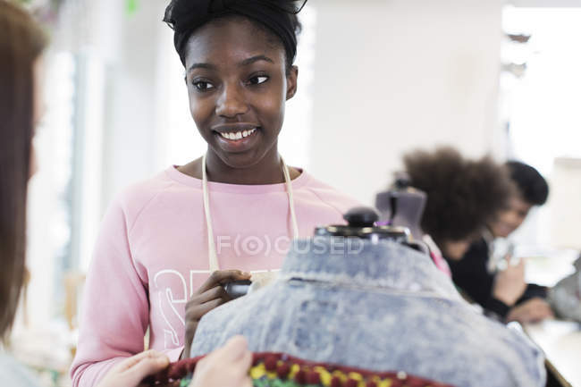 Lächelndes Teenager-Mädchen entwirft Jeansjacke im Modedesign-Kurs — Stockfoto