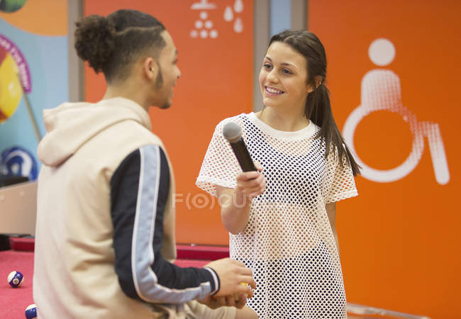 Teenage girl with microphone interviewing boy — Stock Photo