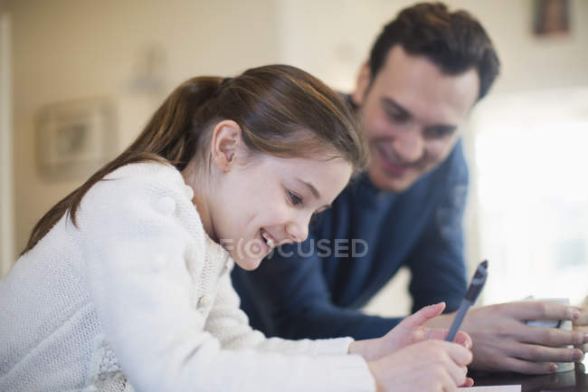 Padre ayudando a hija con la tarea - foto de stock