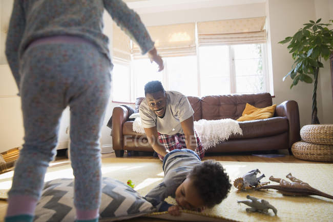 Грайливий батько і діти у вітальні — стокове фото