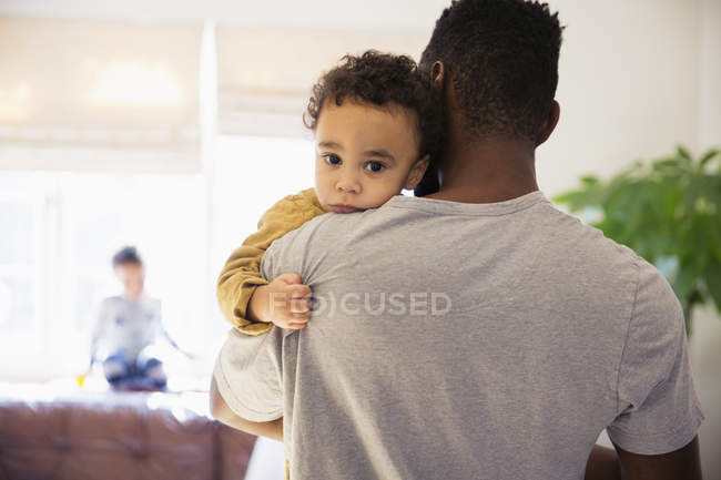 Portrait innocent baby boy over fathers shoulder — Stock Photo