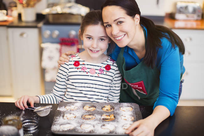 Портрет усміхненої матері і дочки випічки на кухні — стокове фото