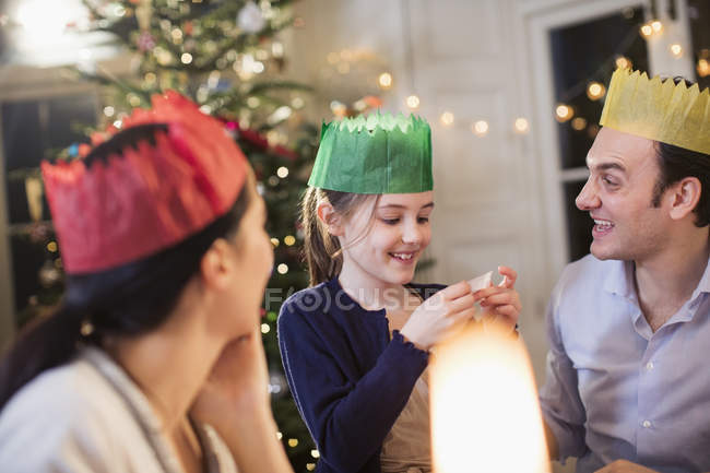 Family in paper crowns enjoying Christmas dinner — Stock Photo