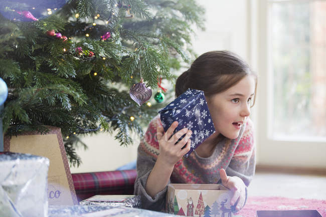 Menina curiosa tremendo presente de Natal — Fotografia de Stock