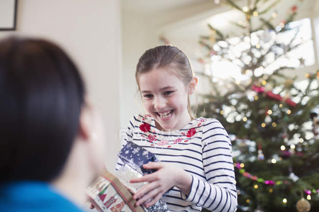 Menina feliz, ansiosa reunindo presentes de Natal — Fotografia de Stock