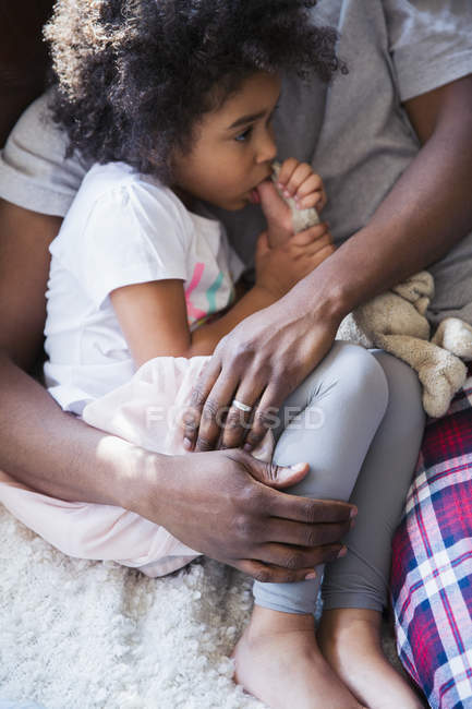 Отец обнимает невинную девушку, сосущую большой палец — стоковое фото