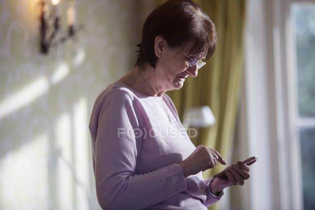 Femme âgée utilisant un téléphone intelligent — Photo de stock