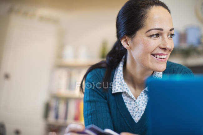 Femme souriante utilisant un ordinateur portable — Photo de stock