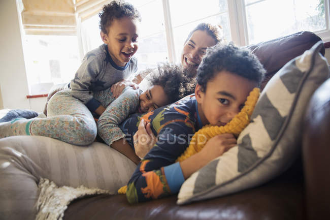 Ritratto felice madre e bambini coccole sul divano del soggiorno — Foto stock