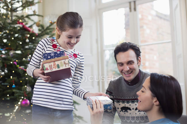 Family opening Christmas gifts in living room — Stock Photo