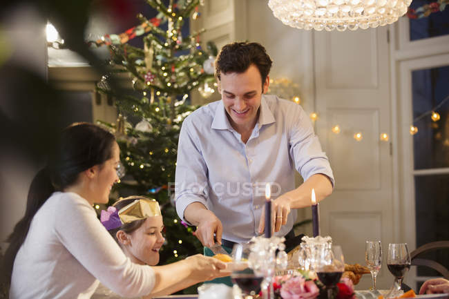 Familia disfrutando de la cena de Navidad con velas - foto de stock